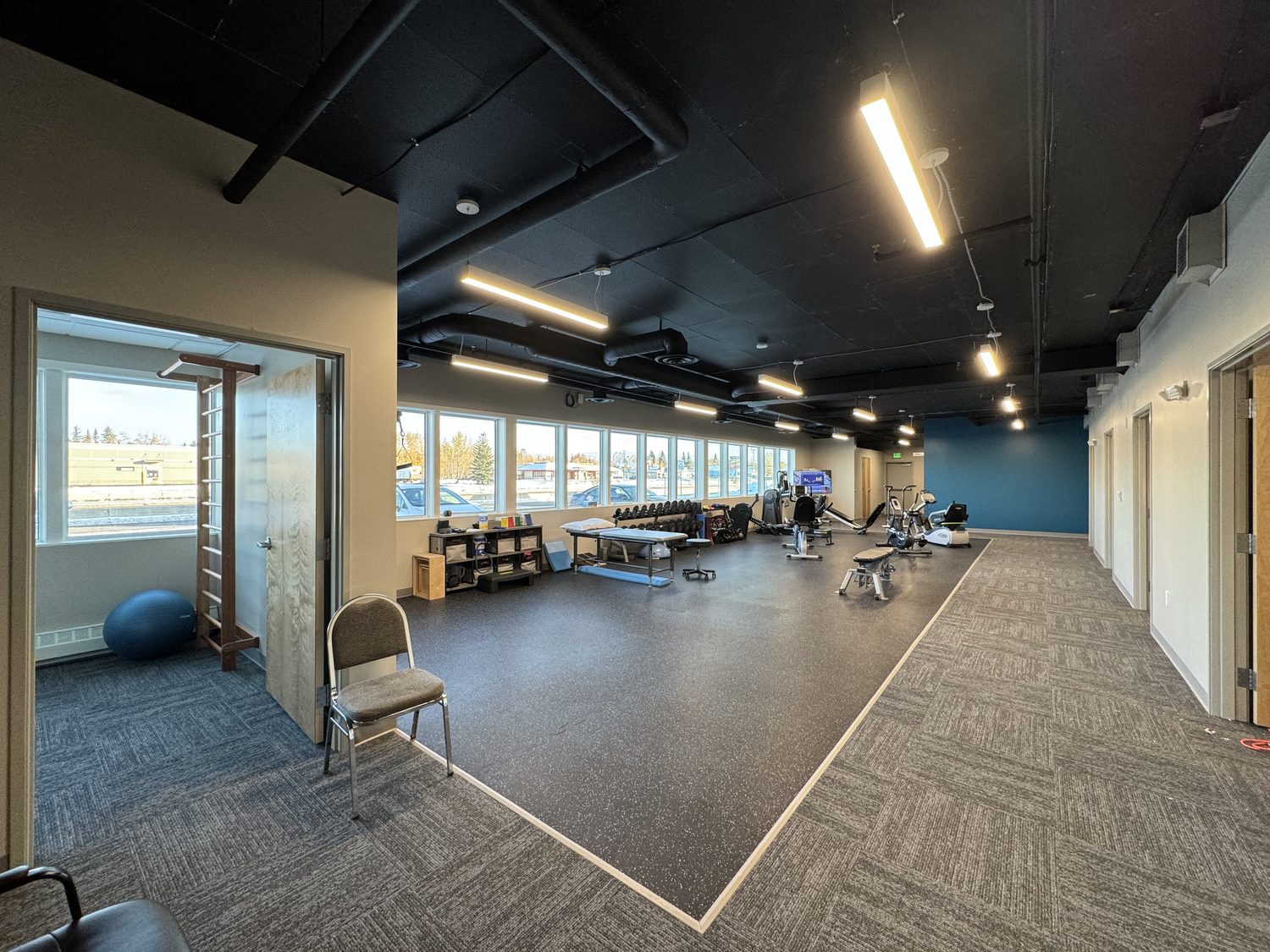 Open physical therapy gym with equipment
